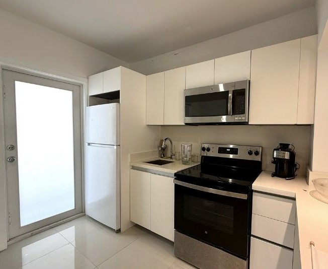 Renovated kitchen with quartz countertops and stainless steel appliances